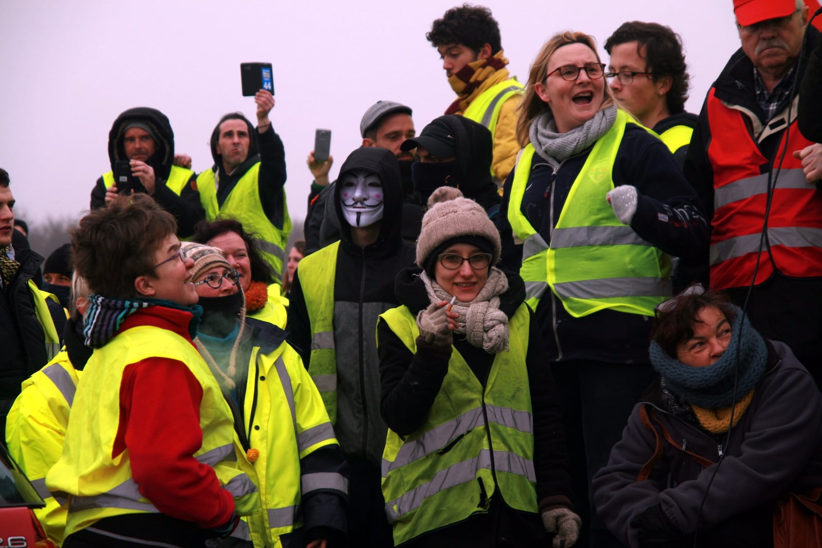 Des gilets jaunes rassemblés à Saint-Nazaire en février 2019, sourires et téléphones levés.